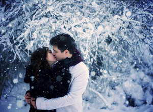 Dating couple kissing in the snow at Christmas